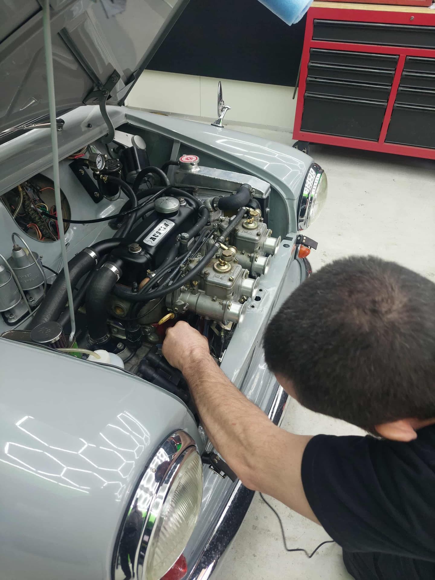 Tuner working on classic car carburettors in the workshop